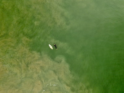man on body of water near surfboard thumbnail