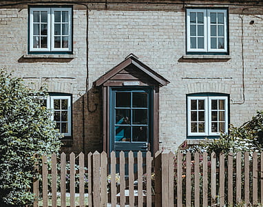 brown wooden fence in front of brown brick house thumbnail