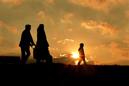 silhouette of man, woman, and child walking during sunrise thumbnail