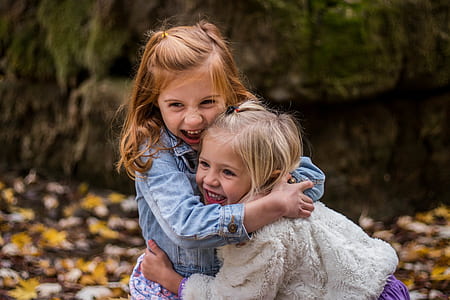 2 Girls Hugging Each Other Outdoor during Daytime thumbnail