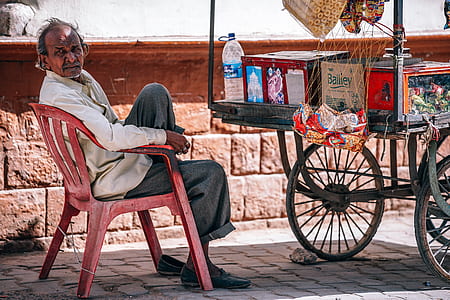 man in white dress shirt sitting beside cart thumbnail