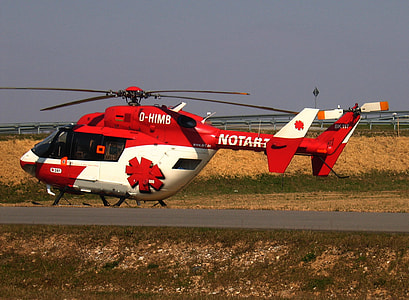 red and white helicopter on grass field thumbnail