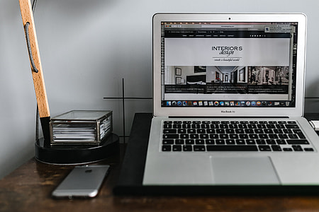 Front view of laptop and mobile phone on the wooden desk thumbnail