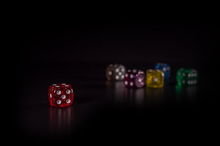 red die separated to multi-color dice in bokeh photography thumbnail