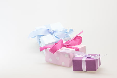 three pink, purple, and blue gift boxes on white background thumbnail