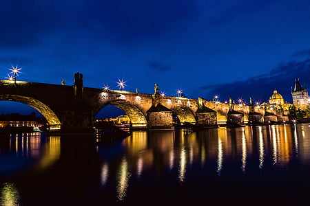 brown concrete bridge across river with lights during nighttime thumbnail