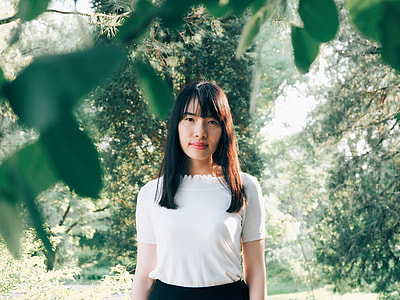black haired woman in white shirt surround by green trees during daytime thumbnail