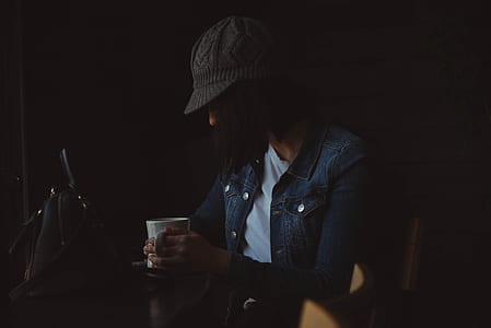 woman wearing blue button-up jacket holding white ceramic mug thumbnail