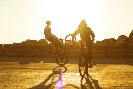 two person riding a bicycle doing tricks thumbnail