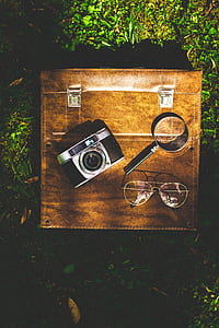 black and silver point-and-shoot camera beside magnifying glass thumbnail