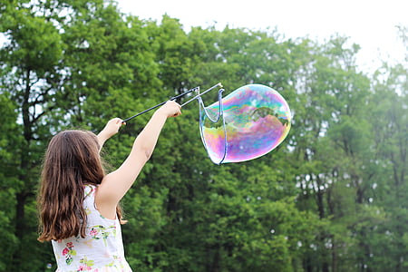 girl playing bubble near forest thumbnail