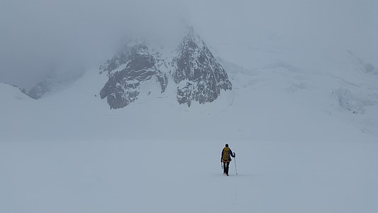 person standing on snow with snow stick near snow covered mountain thumbnail