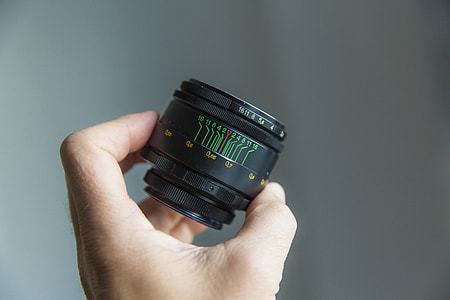 person holding black camera lens thumbnail