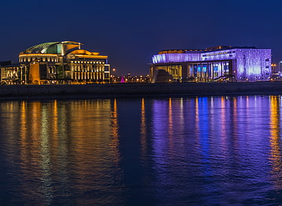 two lighted buildings near body of water during nighttime thumbnail