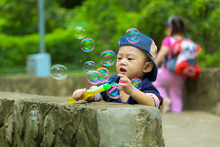 toddler boy playing bubbles at daytime thumbnail