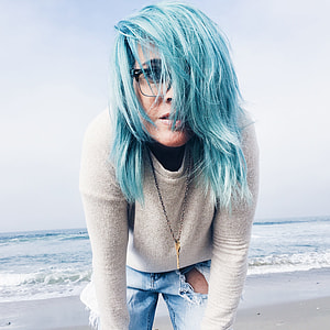 woman in grey sweater and blue denim bottom standing near body of water during daytime thumbnail