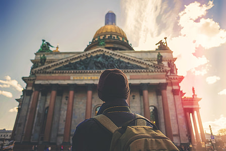 person wearing backpack and facing on mosque thumbnail
