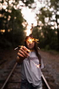 woman holding lit sparkle stick in selective focus photography thumbnail