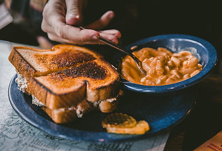 person scooping food with toasted bread on plate thumbnail