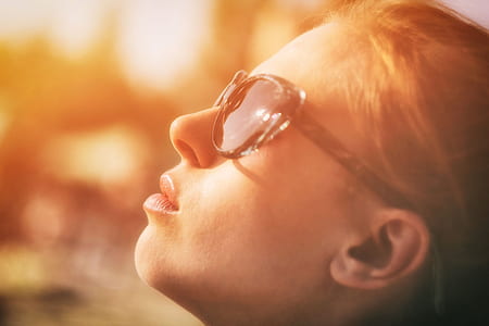 photography of woman wearing sunglasses looking towards sky thumbnail