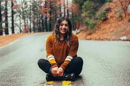selective focus photo of woman sitting on roadway thumbnail