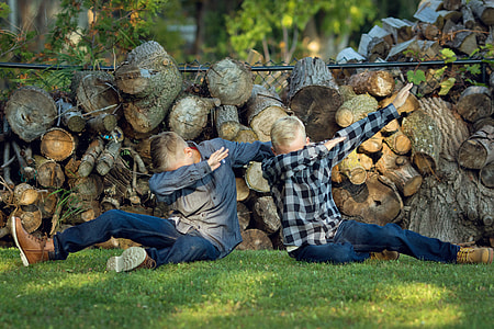 two boys sitting on grass and rising their arms thumbnail