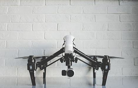 white and black drone beside wall thumbnail