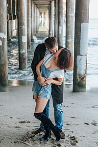 man kissing a woman under a pier thumbnail
