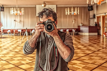 man taking photo using Canon bridge camera thumbnail