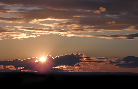 sun behind dark clouds during dawn thumbnail