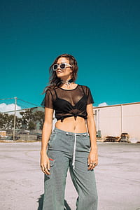 woman standing on concrete floor outside the building during daytime thumbnail