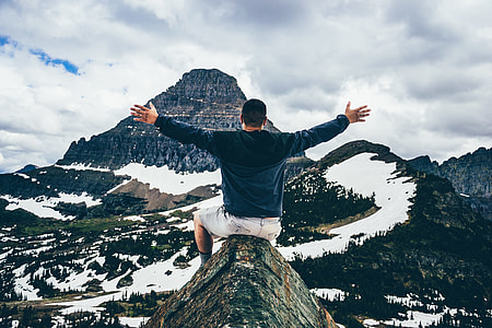 man on top of a mountain spreading his hand thumbnail