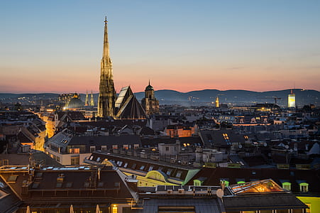 brown roof buildings with city lights under ornage and gray sky thumbnail