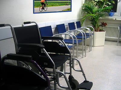 black and gray wheelchair beside blue chair with gray steel frame thumbnail