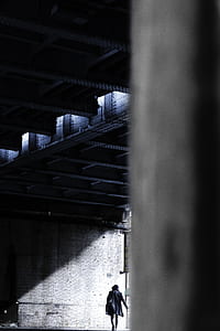 person walking towards the wall with light shining through thumbnail