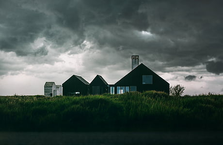 black house surrounded by green grass thumbnail