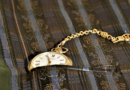 gold-colored pocket watch on brown pocket thumbnail