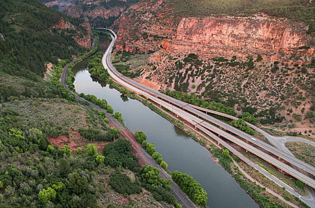 bird's eye photo of river surrounded by mountains and trees thumbnail