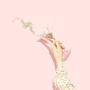 person holding martini glass with glitters thumbnail