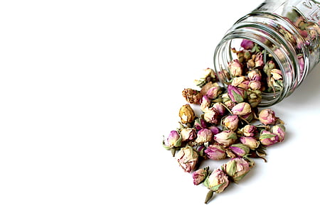 glass jar spilling dried pink roses thumbnail