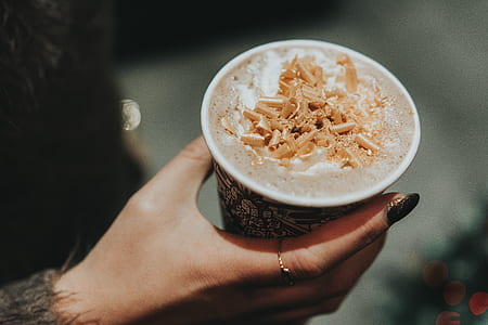 person holding white and black cup filled with brown chocolate thumbnail