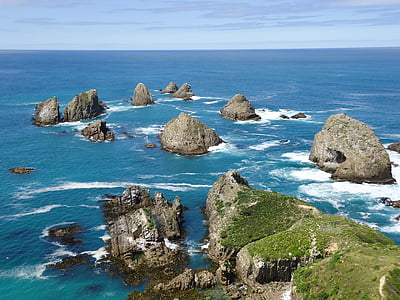 rock formations on sea under blue sky at daytime thumbnail
