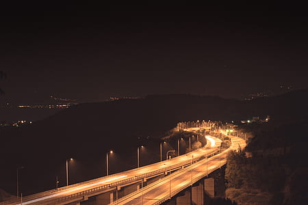 lighted concrete road bridge during night time thumbnail