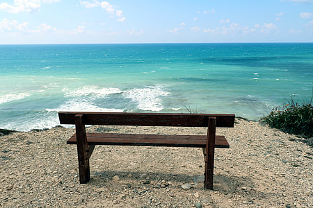 empty brown wooden bench with a view of sea at daytime thumbnail