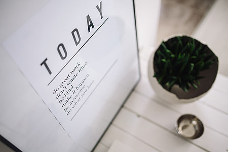Small wooden table with a potted plant and a grey wallet thumbnail