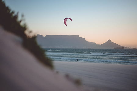 person taking photo of man parasailing thumbnail