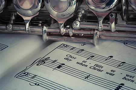 silver flute on top of open music book thumbnail