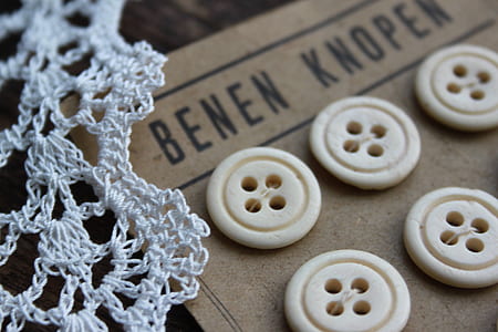six white buttons on brown cloth thumbnail
