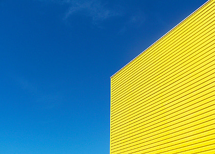 yellow painted building under blue sky during daytime thumbnail