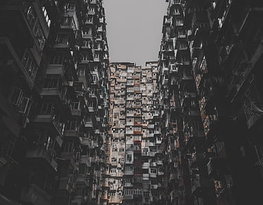 low angle photography of concrete buildings under grey sky thumbnail